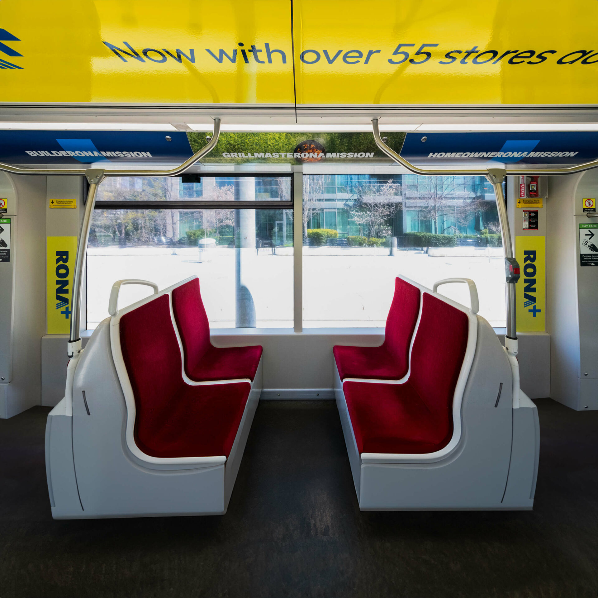 Interior of a tramway wrapped with RONA spring advertising, featuring branded visuals on the walls.