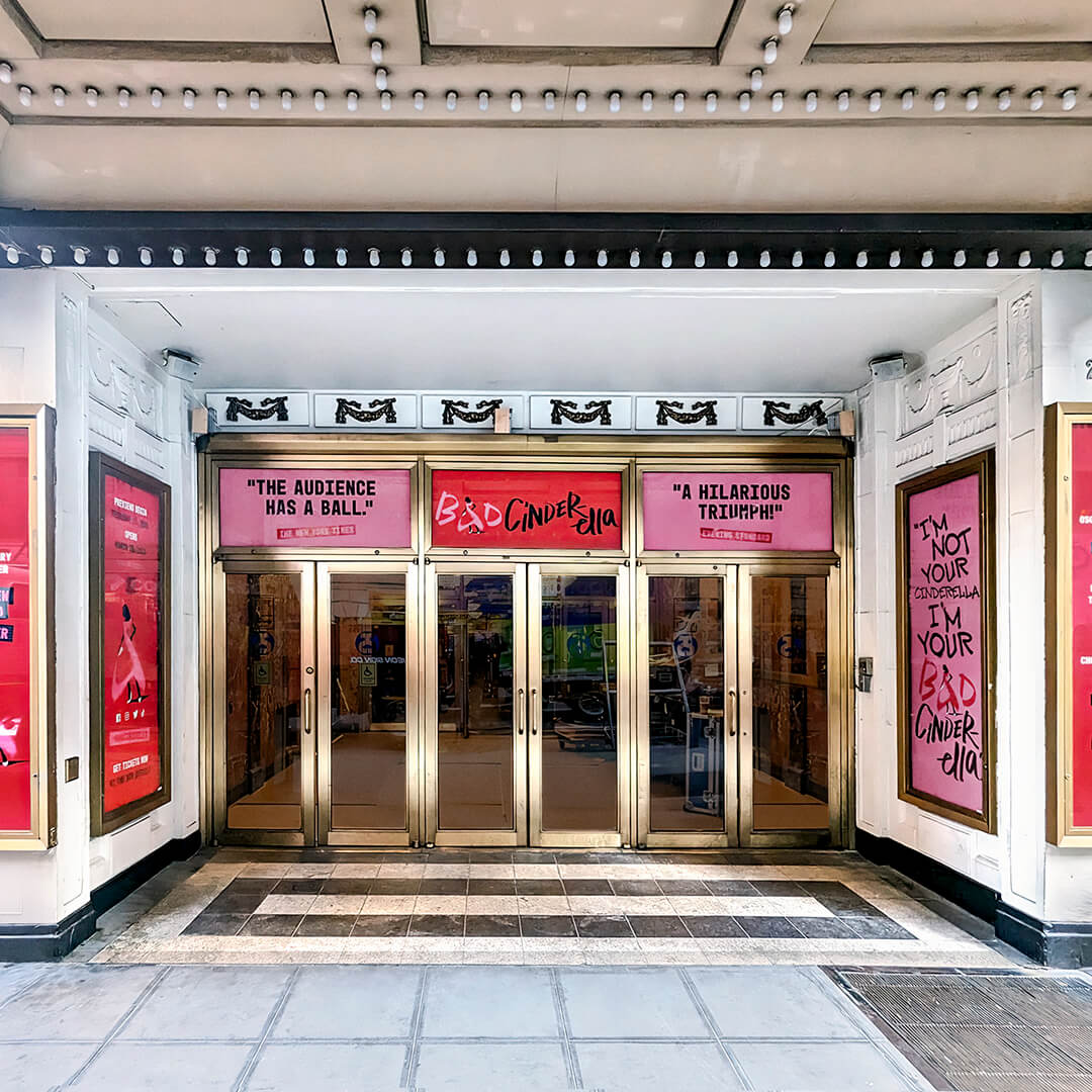 Entrée du théâtre décorée avec les affiches et slogans du spectacle Bad Cinderella.