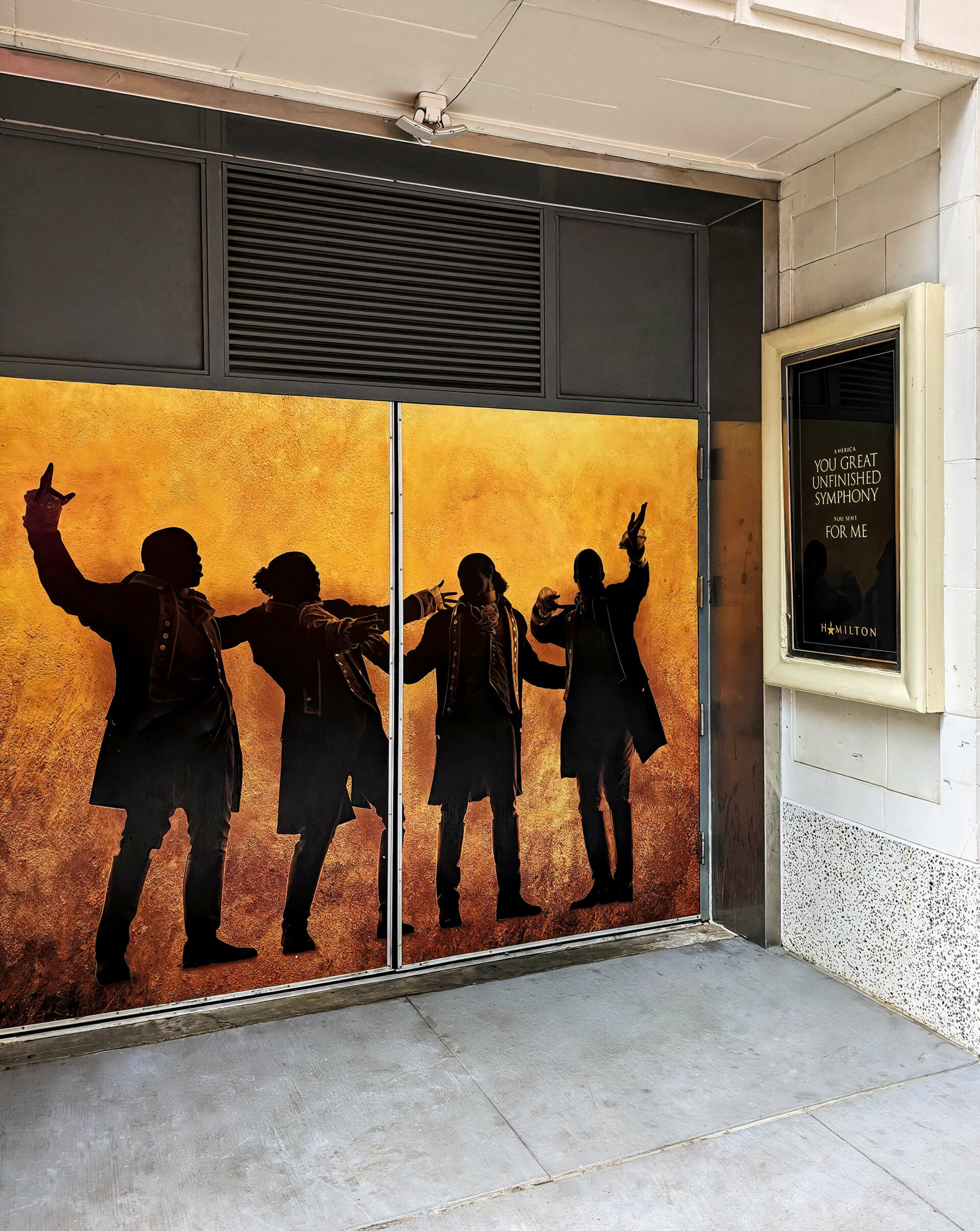 Theater entrance with posters and actor silhouettes from the musical Hamilton.