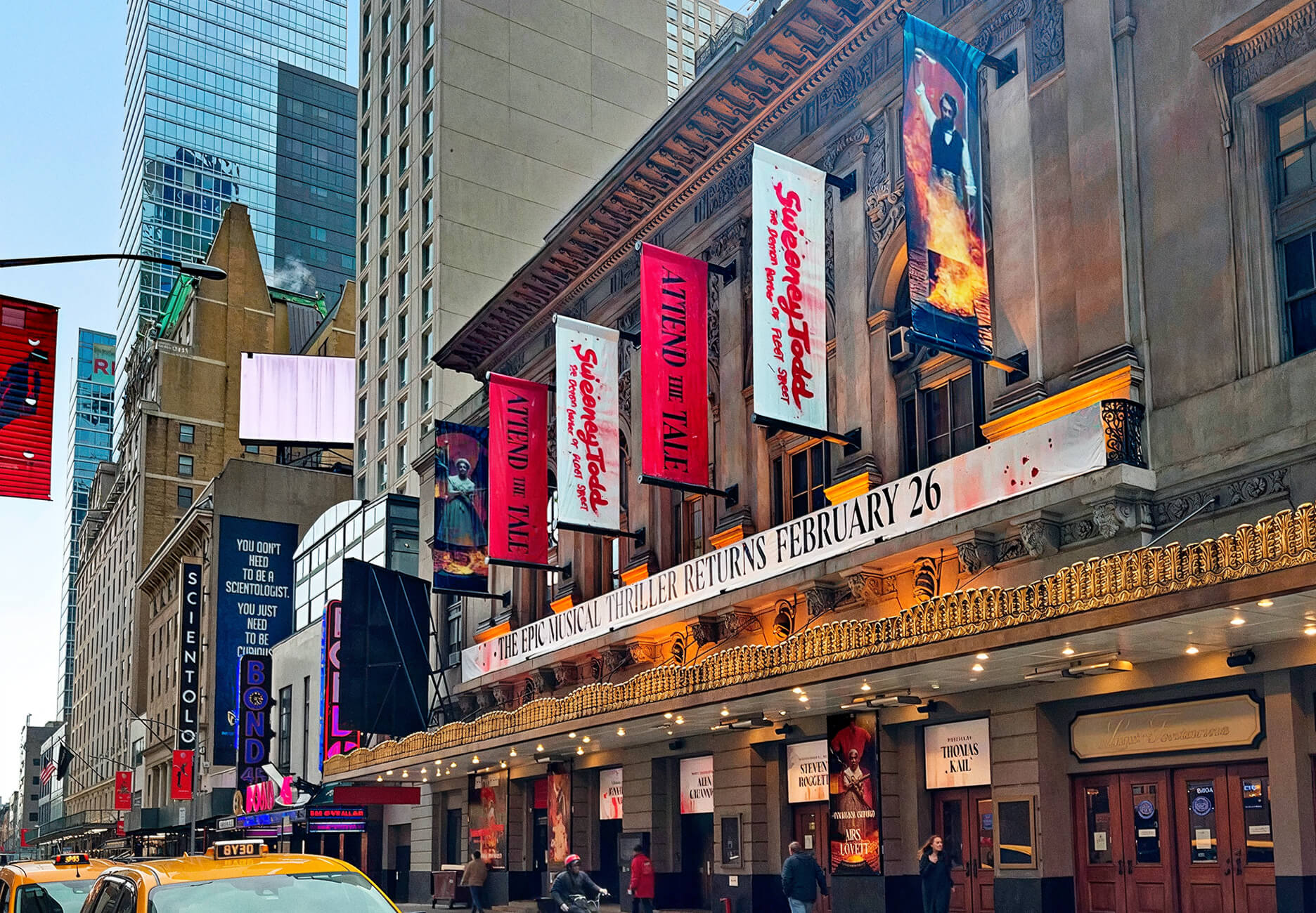 Broadway theater façade decorated with colourful banners promoting the Sweeney Tood musical.